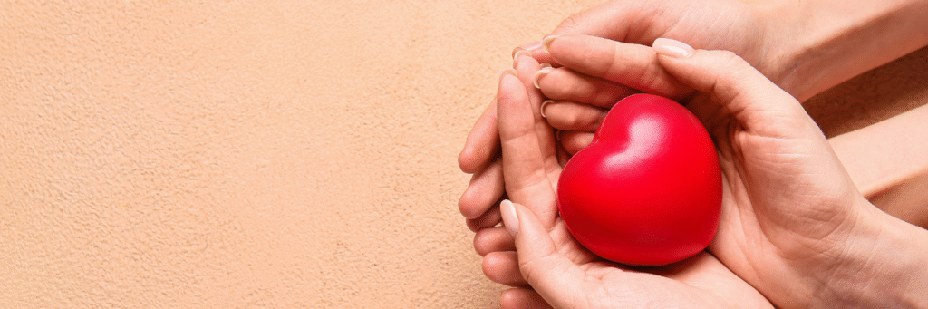 Hands holding a heart symbol representing heart health and care.