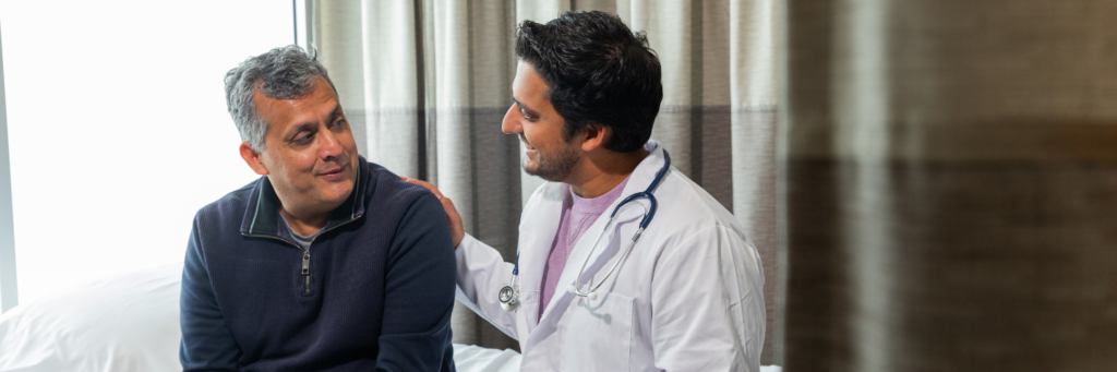 Doctor providing a home consultation to an elderly patient at home through Care247
